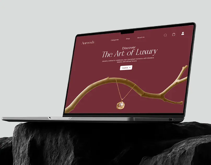 Aureesh website hero, The Art of Luxury, on a laptop resting on dark stone